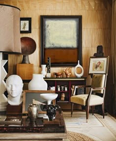 a living room filled with lots of furniture and art on top of a wooden table