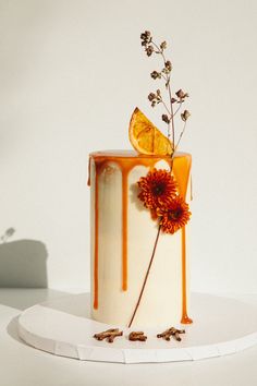 a white cake with orange icing and flowers on top