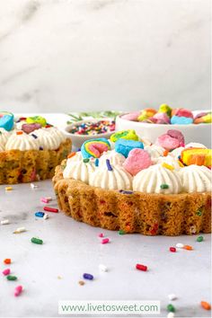 two cakes with white frosting and colorful sprinkles on the top one has a bite taken out of it