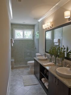 a bathroom with two sinks, a toilet and a walk - in shower next to each other