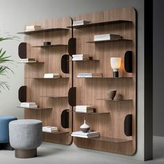 a book shelf with books on it next to a blue chair and potted plant