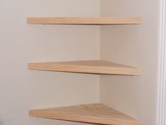 three wooden shelves in the corner of a room