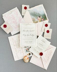 the wedding stationery is laid out on top of each other, including cards and envelopes