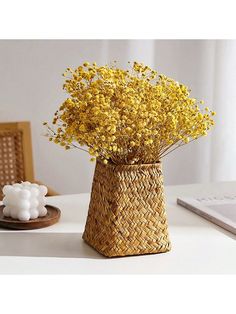 a vase with yellow flowers sitting on a table