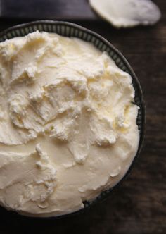 a bowl filled with whipped cream on top of a wooden table