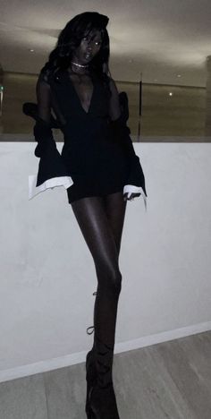 a woman is dressed in black and posing for the camera