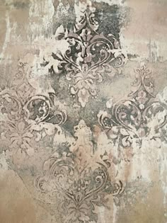 an old wall with peeling paint and floral designs on the side, as seen from above