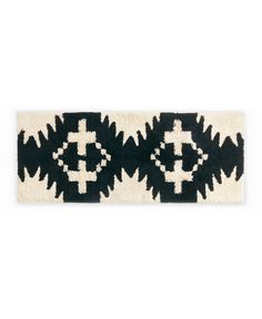 a black and white rug with an abstract design on the bottom, in front of a white background