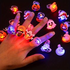 a person's hand with glowing halloween rings on it