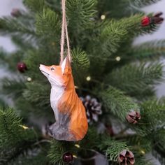 an ornament shaped like a fox hanging from a christmas tree