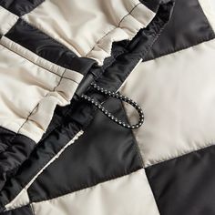 a black and white jacket with a chain on it