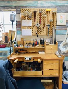 a workbench with lots of crafting supplies and tools hanging on the wall