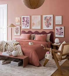 a bedroom with pink walls and pictures on the wall