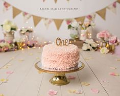 a pink cake sitting on top of a wooden table