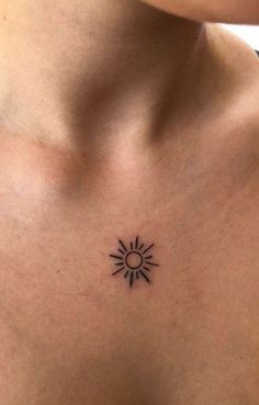 a woman's chest with a small sun tattoo on her left side ribcage