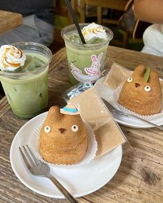 two desserts are sitting on plates with forks and spoons in front of them