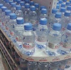 many bottled water bottles on display in a store