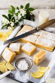 lemon bars are cut into squares on a cutting board