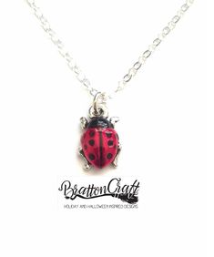 "Everyone is in love with this Hand Painted Red Ladybug Necklace! This is a TierraCast® original charm design. The charm is made in the USA using lead-free Britannia pewter with a nickel compliant fine silver double plating. The charm is approximately 1/2 inches long and 3/8 inches wide. Kimberly hand painted the ladybugs using a nontoxic epoxy resin made with organic compounds. The 16 inch chain shown is sterling silver, 1.5mm, flat cable style, finished with a lobster claw clasp and made in th Red Heart-shaped Novelty Jewelry, Cute Handmade Red Charm Necklaces, Cute Handmade Red Charm Necklace, Cute Red Handmade Charm Necklace, Nickel-free Red Themed Jewelry, Nickel-free Themed Red Jewelry, Cute Red Charm Necklace For Gift, Cute Red Charm Necklaces For Gifts, Themed Red Nickel-free Jewelry