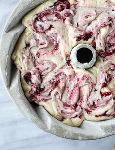 a cake with white icing and red toppings in a pan on a table