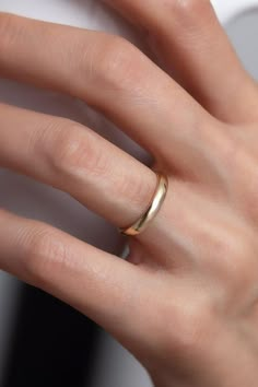 a woman's hand with a gold ring on her finger and the other hand