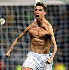 a shirtless male soccer player with his mouth wide open and one foot in the air