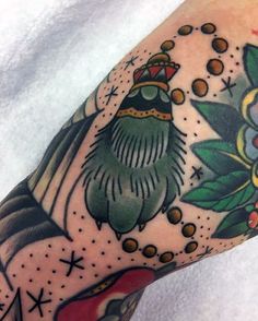 a man's arm with an old school style tattoo on it, featuring a bird and flowers