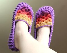 a person's feet wearing crocheted slippers