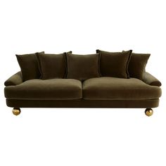 a brown couch with lots of pillows and gold balls on the bottom half of it