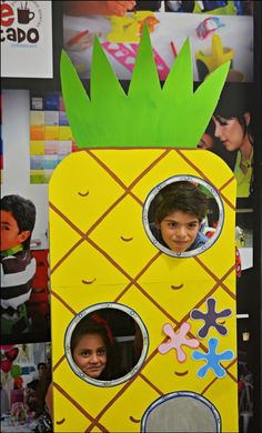 a cardboard cut out of a pineapple with two children's faces on it