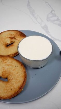 two donuts and a bowl of yogurt on a plate