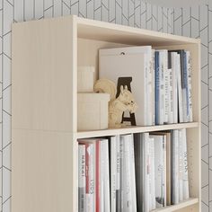 a book shelf filled with books on top of a white tiled wall next to a lamp