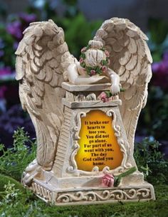 an angel figurine with a poem written on the side and flowers around it