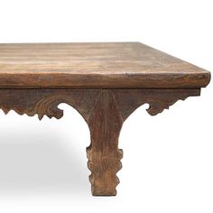 an old wooden table with carvings on the top and bottom, against a white background