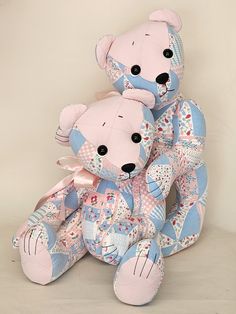 two pink and blue teddy bears sitting next to each other