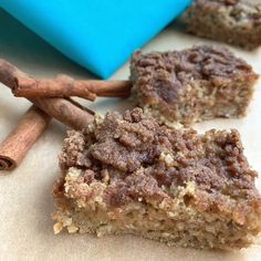 three pieces of cake sitting next to cinnamon sticks