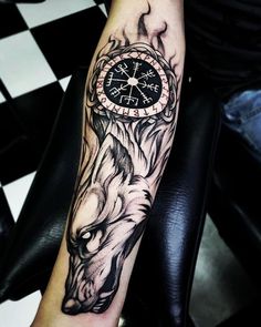 a person with a tattoo on their arm has a clock and wolf head in the background