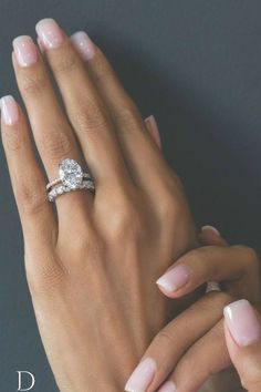 a woman's hand with two rings on her fingers and one holding the other