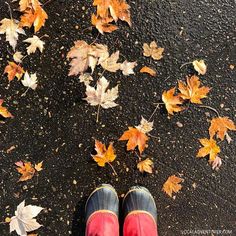 a person standing in front of some leaves on the ground with their feet propped up