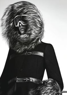 black and white photograph of a woman wearing ski goggles with fur on her head