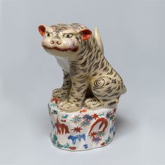 a white tiger figurine sitting on top of a bowl