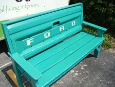 a green bench sitting on the side of a road next to a sign that says ford