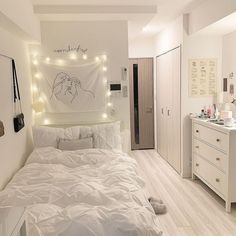 a bedroom with white furniture and lights on the wall