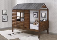 a child's bed with a wooden cabin like structure and white rug on the floor