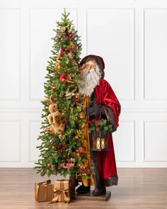 a santa clause standing next to a christmas tree