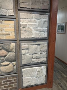 a stone wall with several different colors and sizes on it in a room that has wood flooring