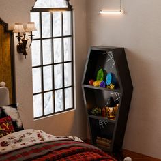 a bedroom with a bed, window and shelf on the wall next to the bed