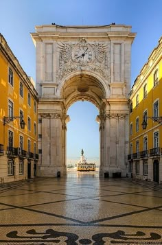 an arch in the middle of a building with a clock on it's side