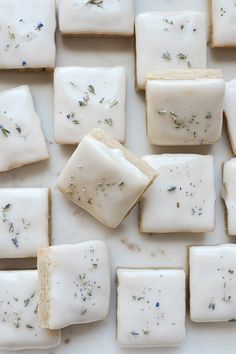 several square pieces of soap sitting on top of each other with lavender sprinkles