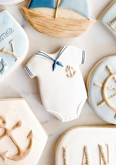 some cookies are laying on top of each other and decorated like boats, ships, and anchors